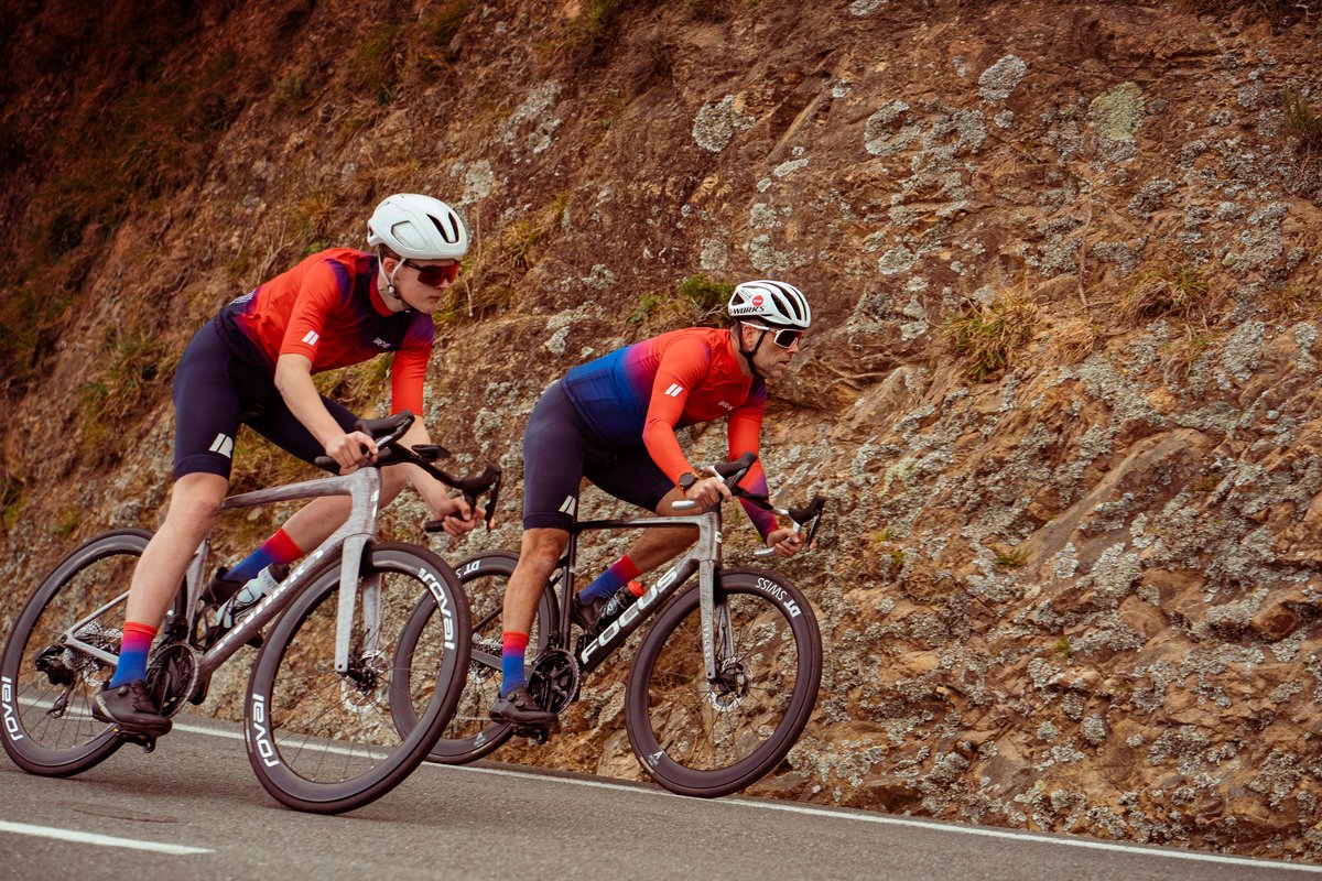 Two iRIDE riders descending beside a rock face.